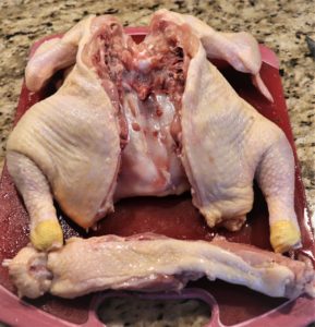 A spatchcock chicken is ready for cooking.  It is a fancy word for removing the spine from the back of the chicken so it will lay flat.  This way, all chicken parts are now on the same level and will cook evenly.   This technique also reduces the cooking time substantially. 