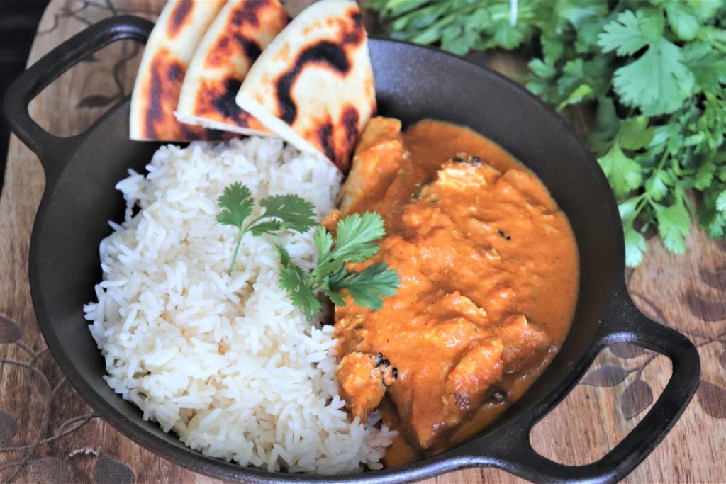 Butter Chicken served alongside white rice and naan bread