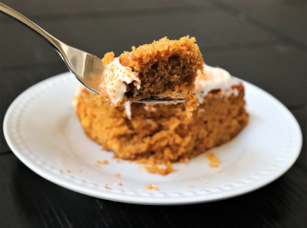 A of the moist and delicious pumpkin cake with wicked cream cheese frosting on a fork ready to devour.