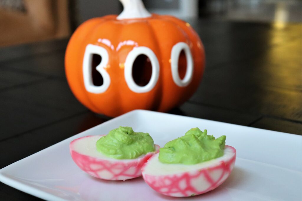 Spooky Bloodshot eye-deviled eggs in the spirit of Halloween.  A unique take on deviled eggs where the yolk mixture is dyed green and the whites of the hard-boiled egg are riddled with crackles of red to mimic broken blood vessels of the eye. Classic deviled egg recipe that is tasty with a creative twist!  