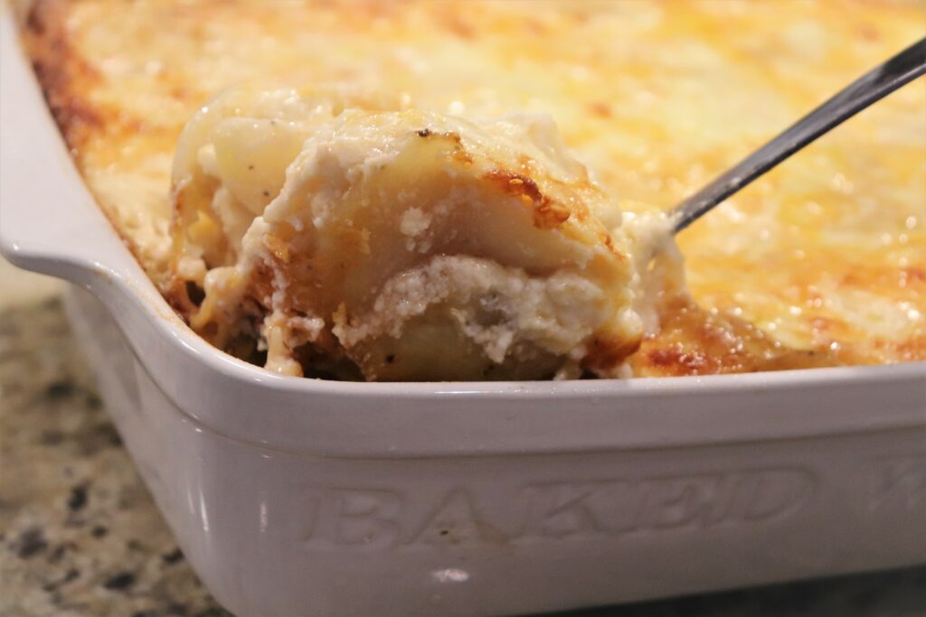 Fork digging in the Scalloped Potatoes Recipe With Cheese